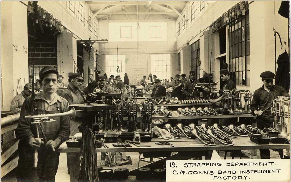Fotografía de principios de siglo XX de uno de los departamentos de la fábrica de instrumentos que C. G. Conn Ltd. tenía instalada en el municipio de Elkhart del estado de Indiana (vía Wikipedia).