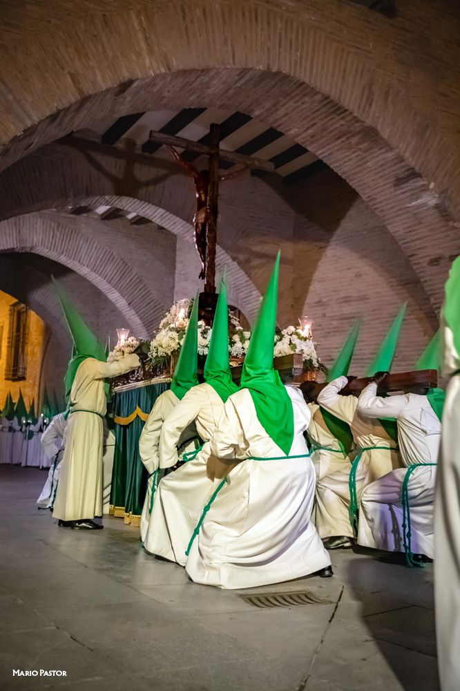 Los portadores del "Cristo de las Siete Palabras" en pleno esfuerzo para levantar la peana en uno de los parajes más espectaculares de la procesión del Lunes Santo, como es el Arco del Deán. Fotografía de Mario Pastor.